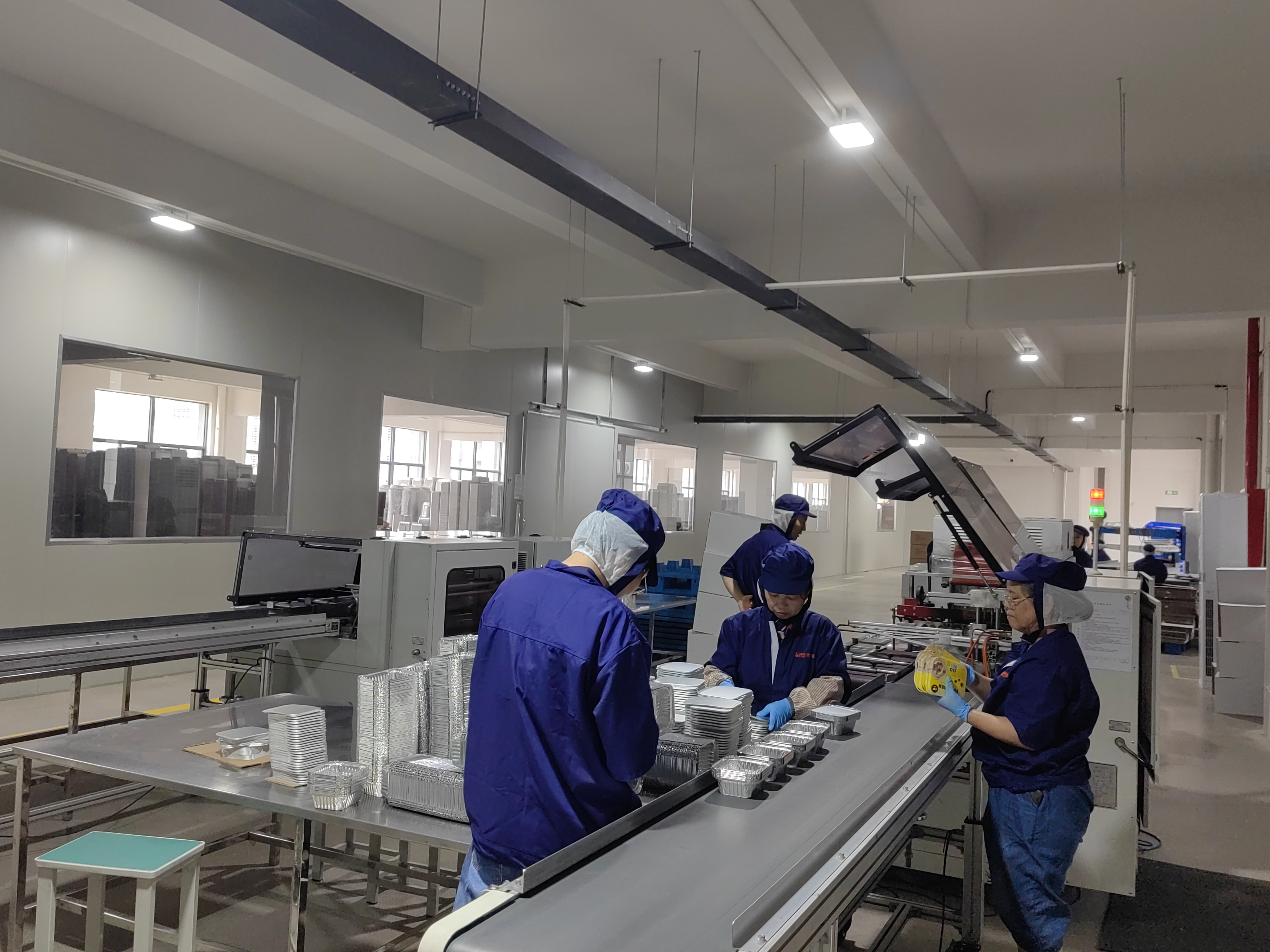 Workers checking and packing aluminum foil containers on the production line