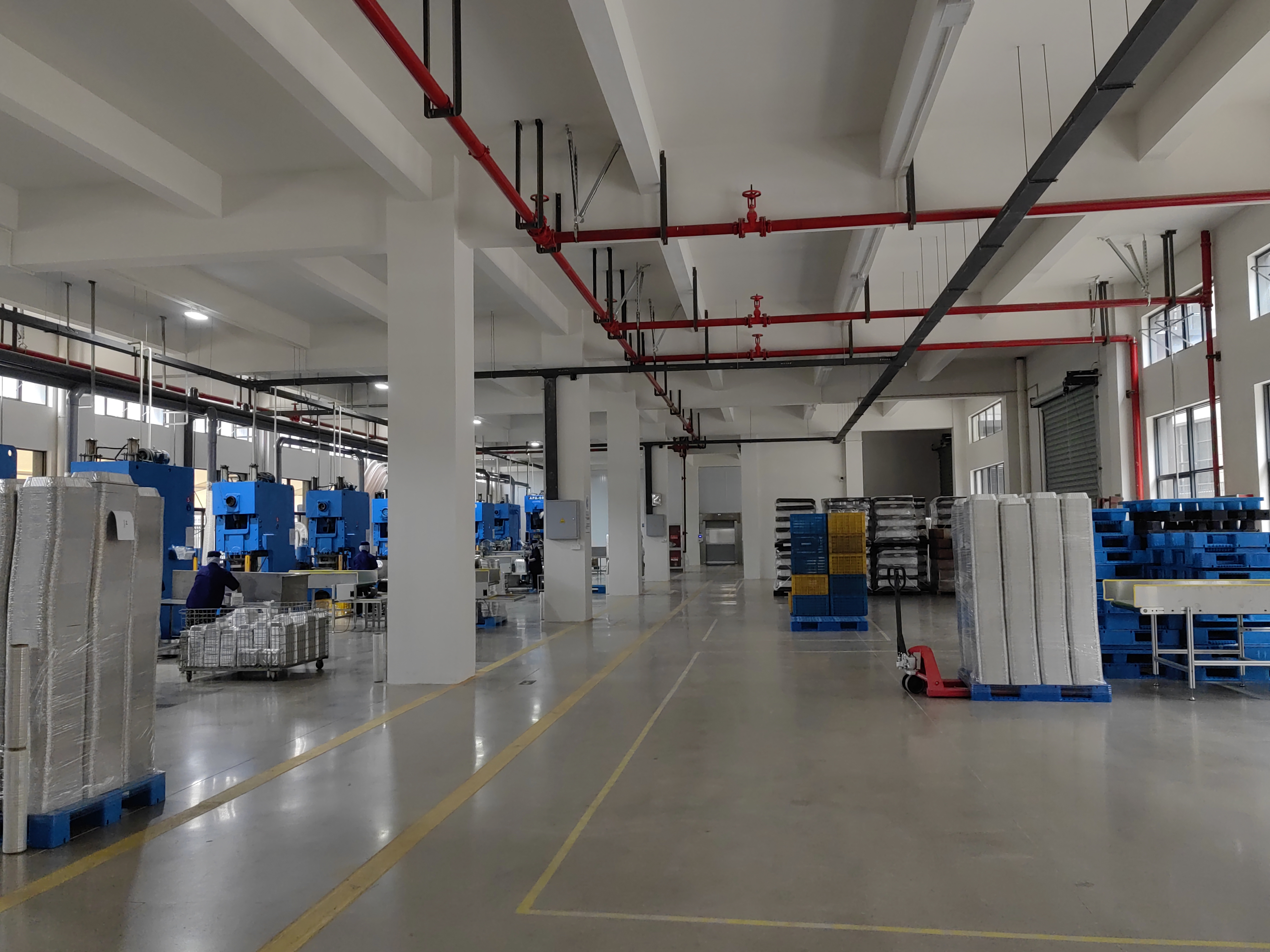 Workshop aisle with finished aluminum foil products and production equipment